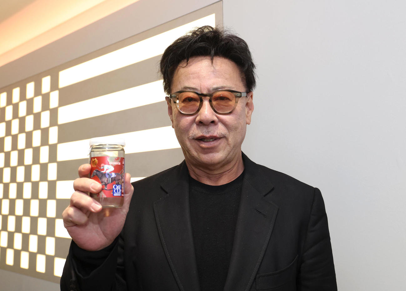 ドウデュースがラベルのワンカップを持つ松島オーナー（撮影・白石智彦）