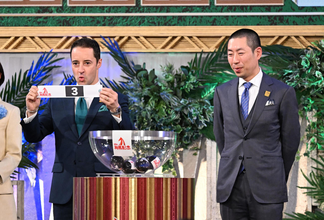第69回有馬記念の枠順公開抽選会でアーバンシックの枠順3番を引いた、ルメール騎手。右は武井師（撮影・千葉一成）