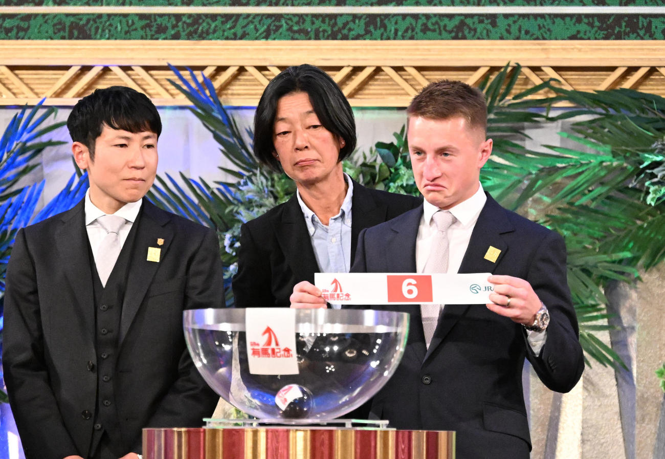 第69回有馬記念の枠順公開抽選会でローシャムパークの枠順6番を引いた、マーカンド騎手。左は田中博師＝2024年12月19日