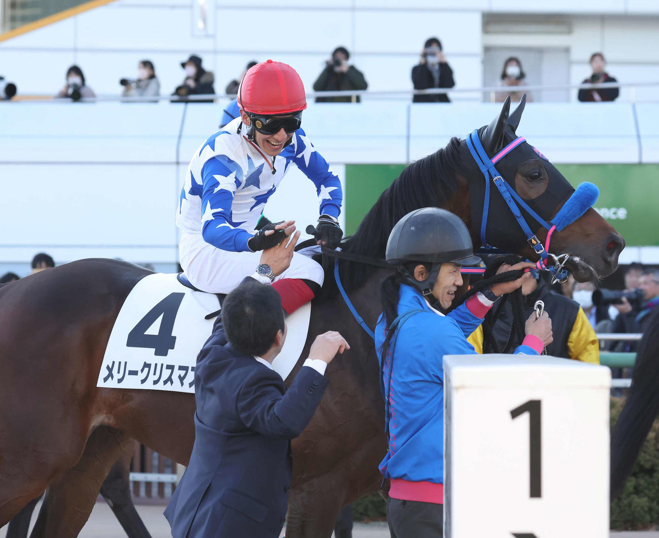中山6R、メリークリスマスで2歳新馬戦を制してスタッフとタッチする菊沢騎手（撮影・丹羽敏通）