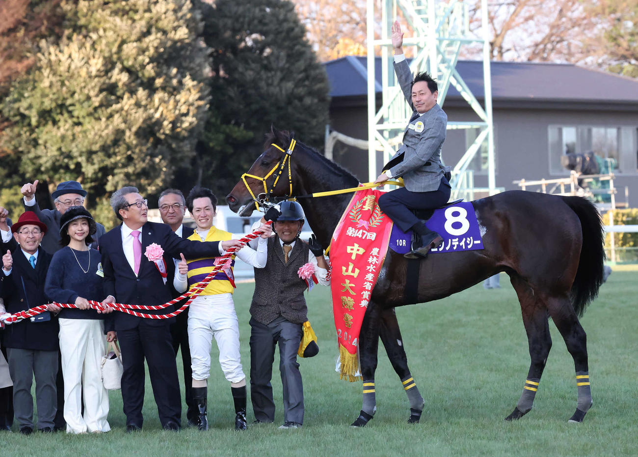中山大障害を制したニシノデイジーの口取り、馬上でポーズをとる勝浦正樹元騎手。西山茂行オーナー、高木登調教師と五十嵐雄祐騎手は暖かく見守った