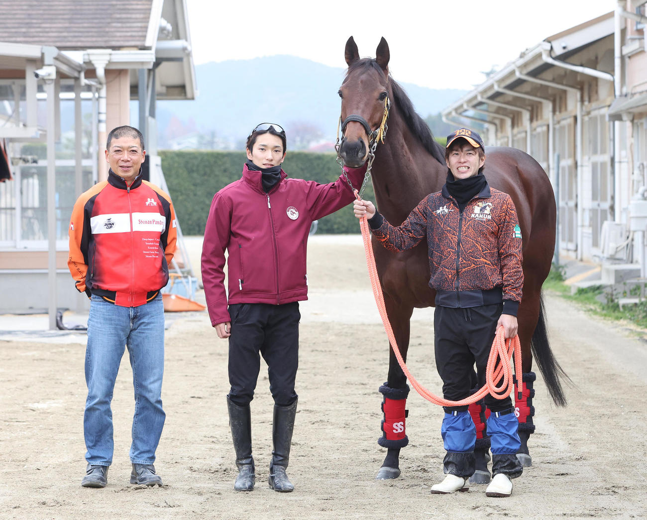 退厩するスタニングローズと記念写真に納まる左から、高野師、坂井騎手（撮影・白石智彦）