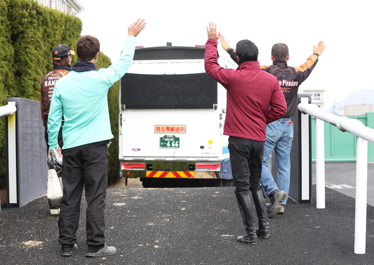 スタニングローズを乗せた馬運車を手を振って見送る高野師（右）と坂井騎手（右から2人目）と厩舎スタッフ（撮影・白石智彦）
