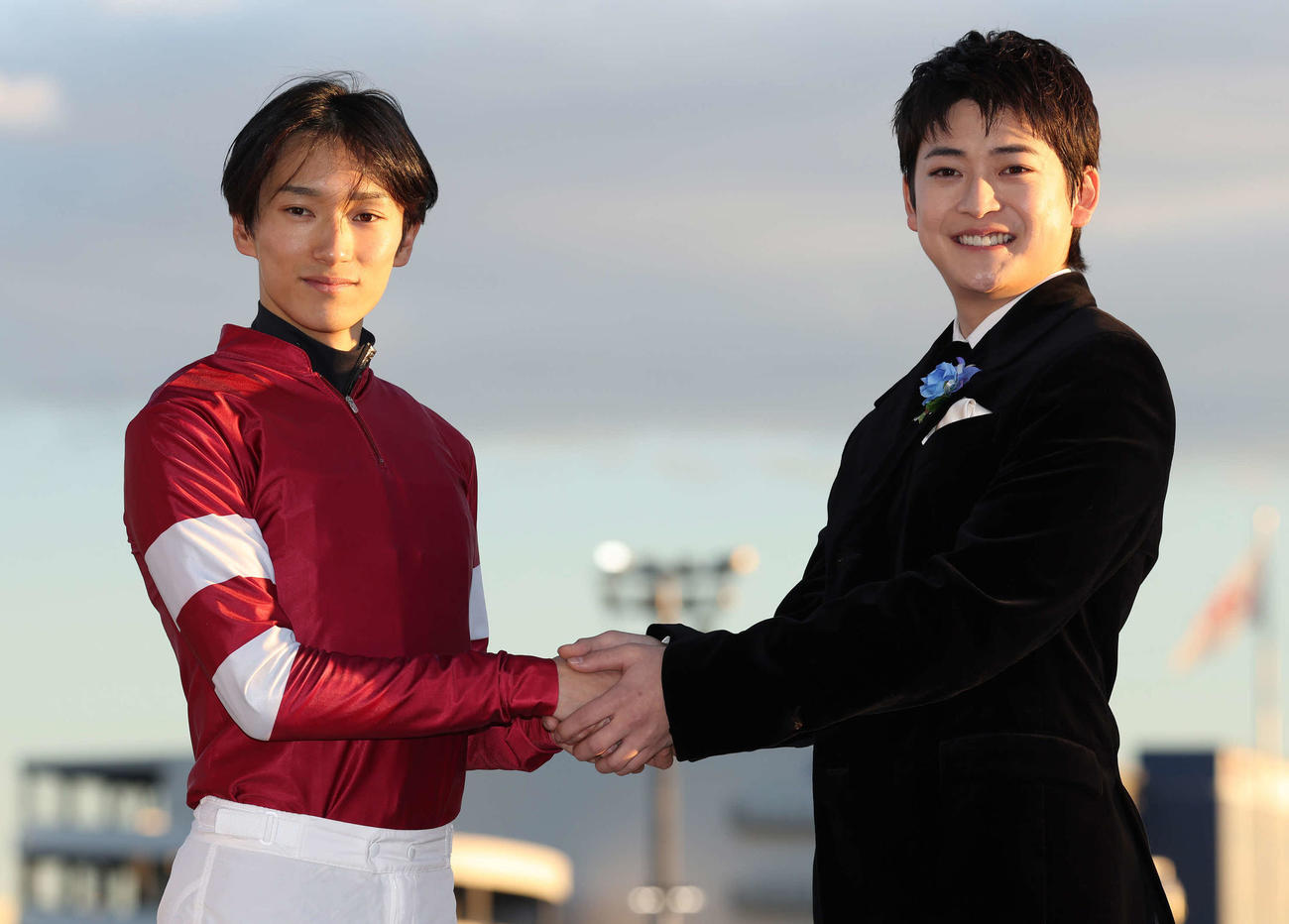 プレゼンターの高橋文哉（右）と写真に納まる坂井騎手（撮影・丹羽敏通）