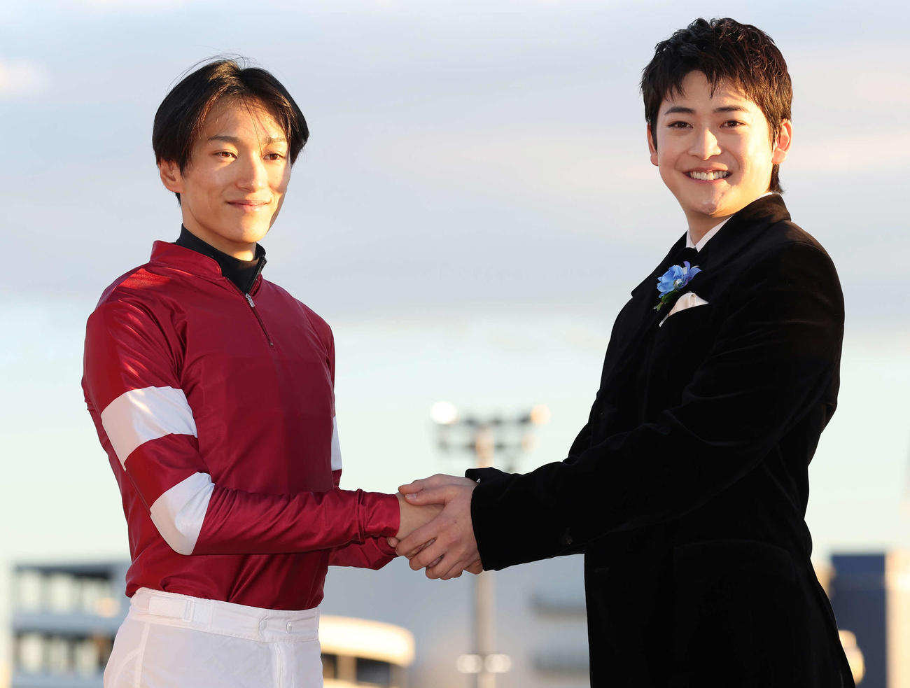 プレゼンターの高橋文哉（右）と写真に納まる坂井騎手（撮影・丹羽敏通）