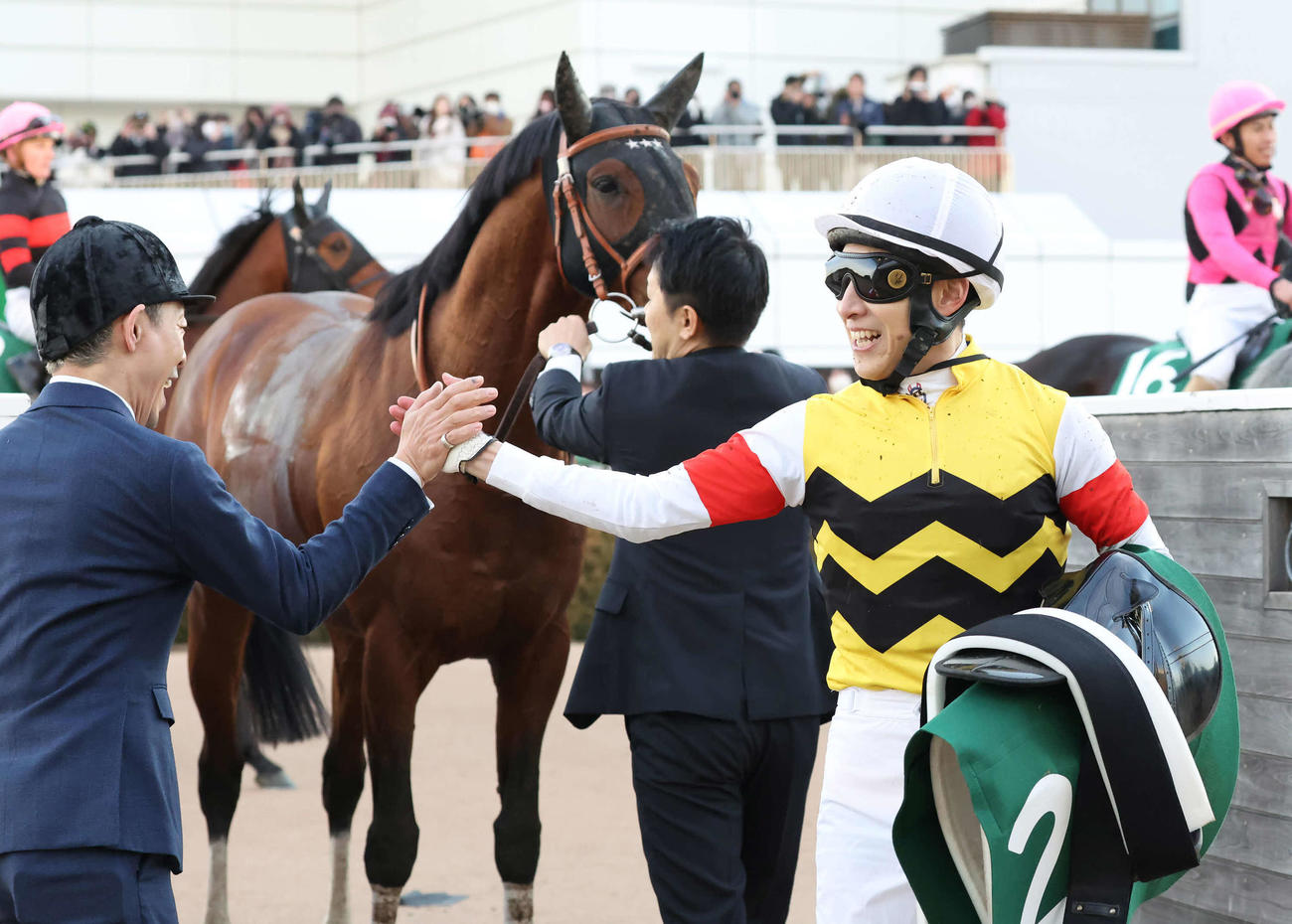 アルナシームで中山金杯を制して担当厩務員とタッチを交わす藤岡佑騎手（撮影・丹羽敏通）