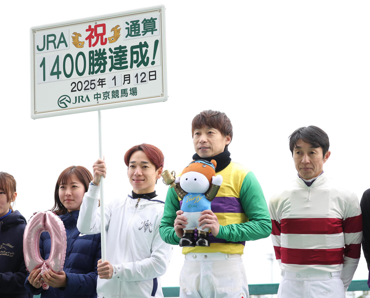 騎手仲間と記念写真に納まるJRA通算1400勝を達成した池添騎手（右から2人目）（撮影・白石智彦）