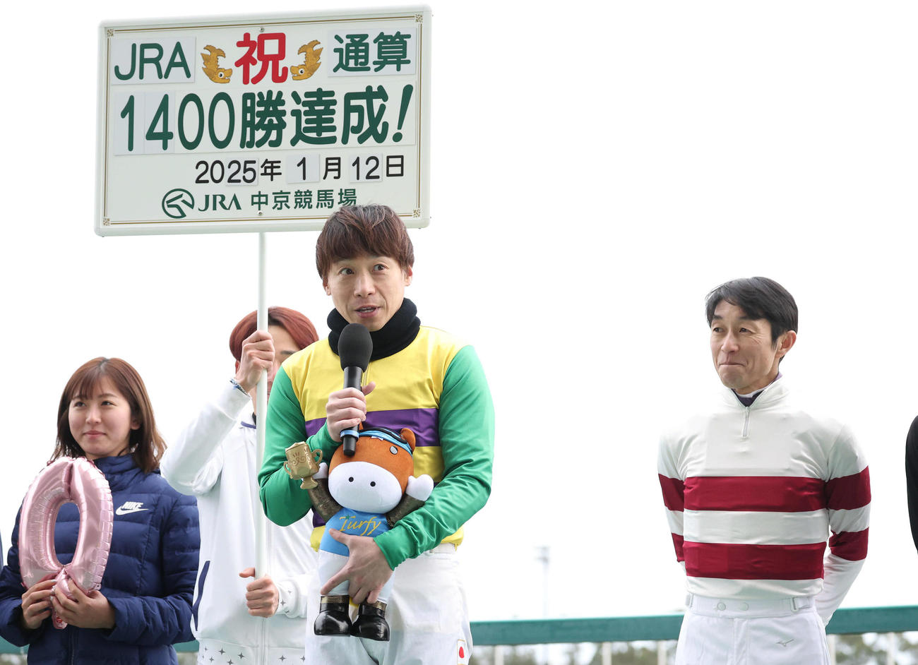 JRA通算1400勝を達成してインタビューに答える池添騎手と見つめる武豊騎手（撮影・白石智彦）