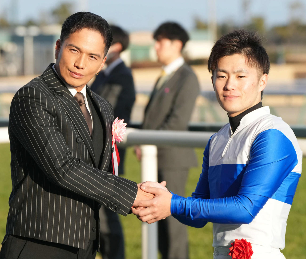 日経新春杯をロードデルレイで制した西村淳騎手（右）はプレゼンターの市原隼人と握手をかわす