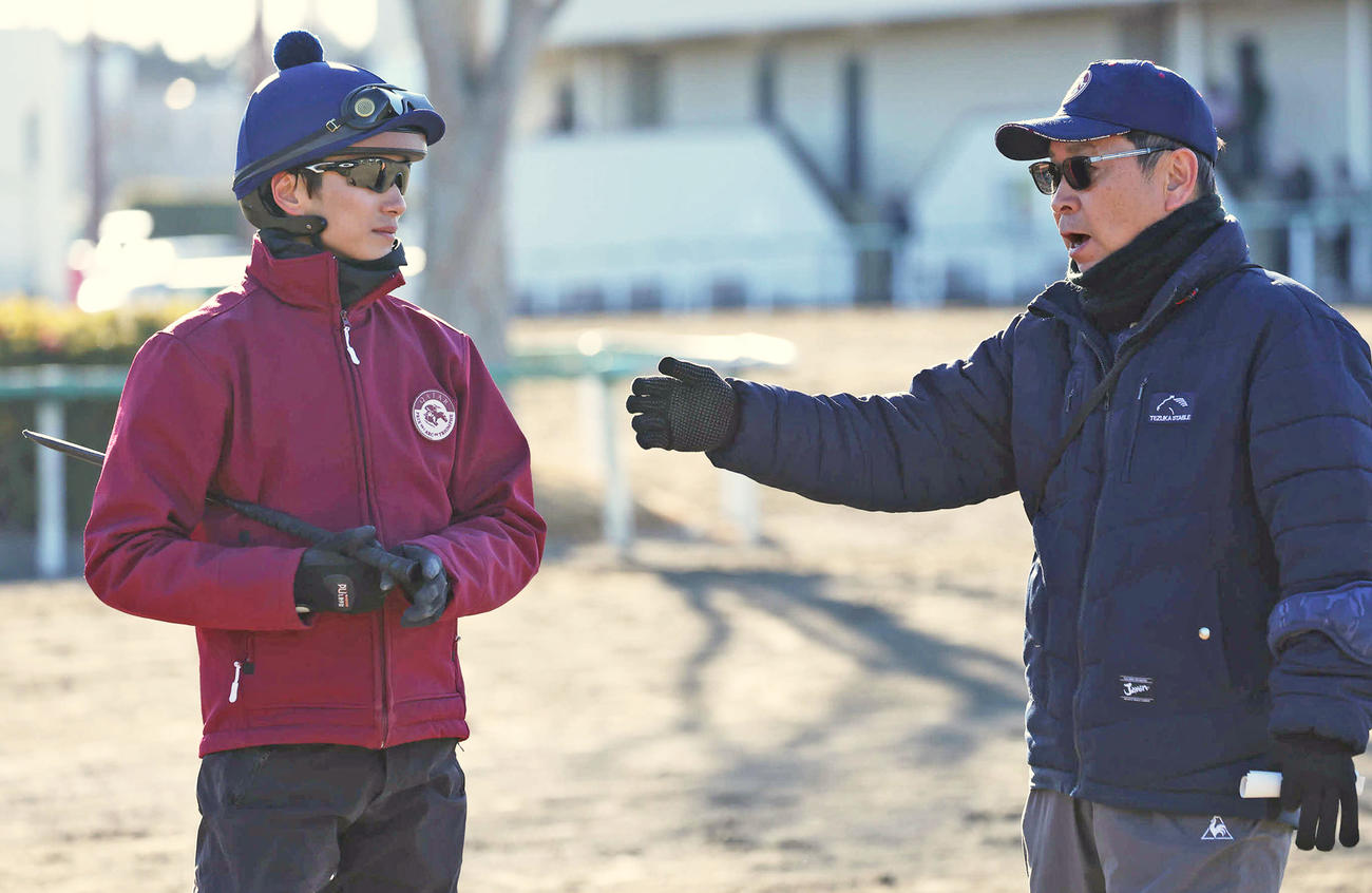 マスカレードボールの追い切りを終えて坂井騎手と話す手塚師（撮影・丹羽敏通）