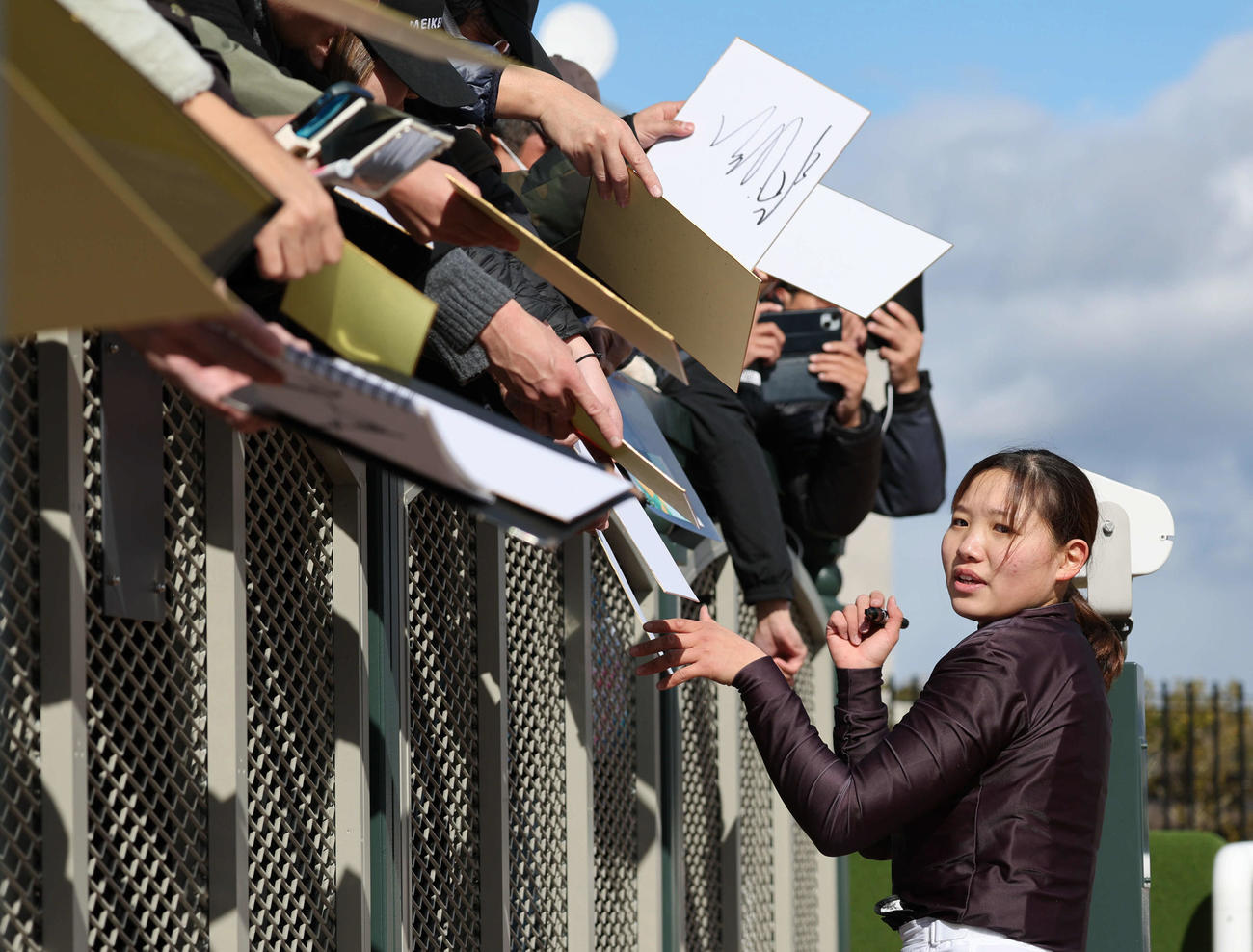 京都8R、4歳以上2勝クラスを制した小林美駒騎手はファンにサイン（撮影・西尾就之）