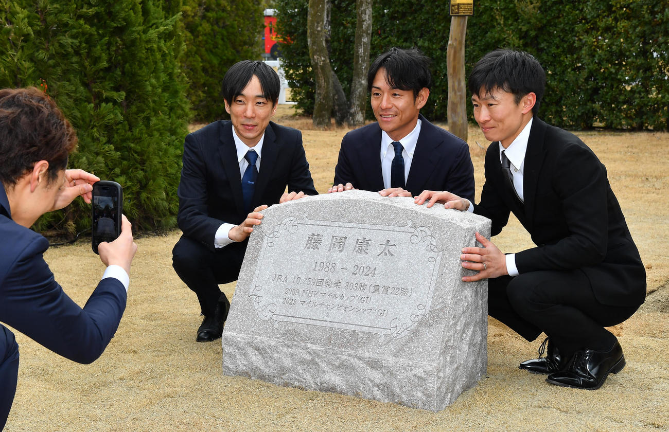 故・藤岡康太騎手追悼植樹式で同期の3人が石碑とともに写真に納まる、左から田中騎手、浜中騎手、荻野琢騎手