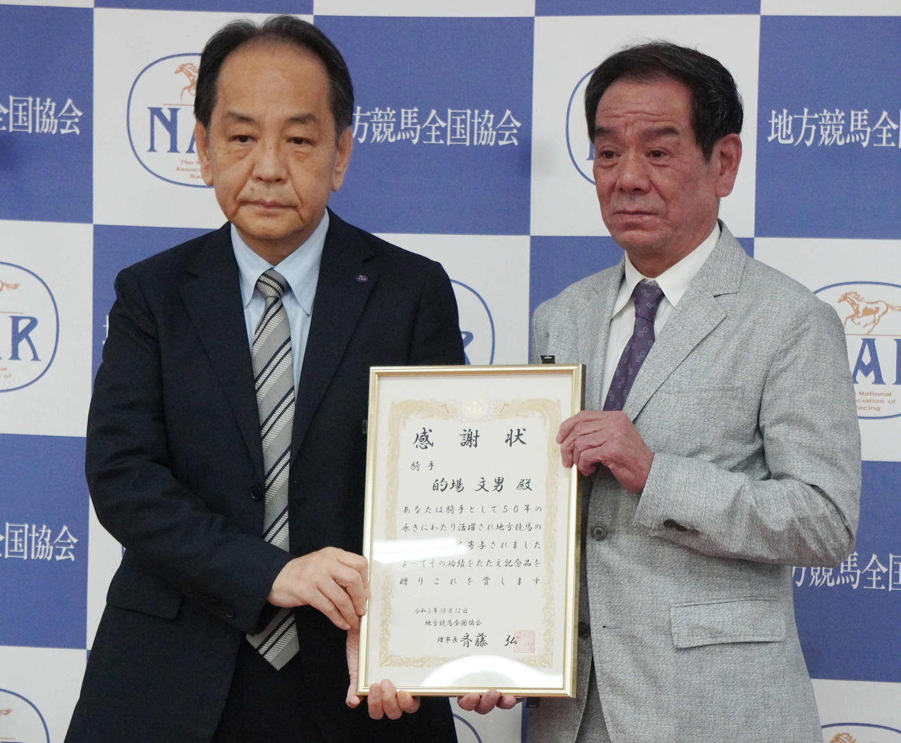23年10月、感謝状を贈呈される的場文男騎手（右）と斉藤弘地方競馬全国協会理事長