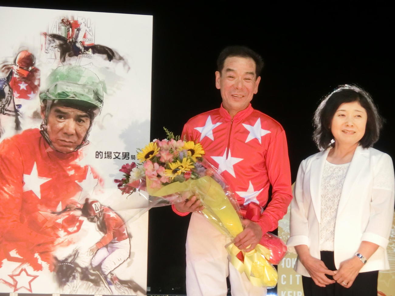 7000勝祝賀セレモニーに登場した的場騎手。右は尚子夫人
