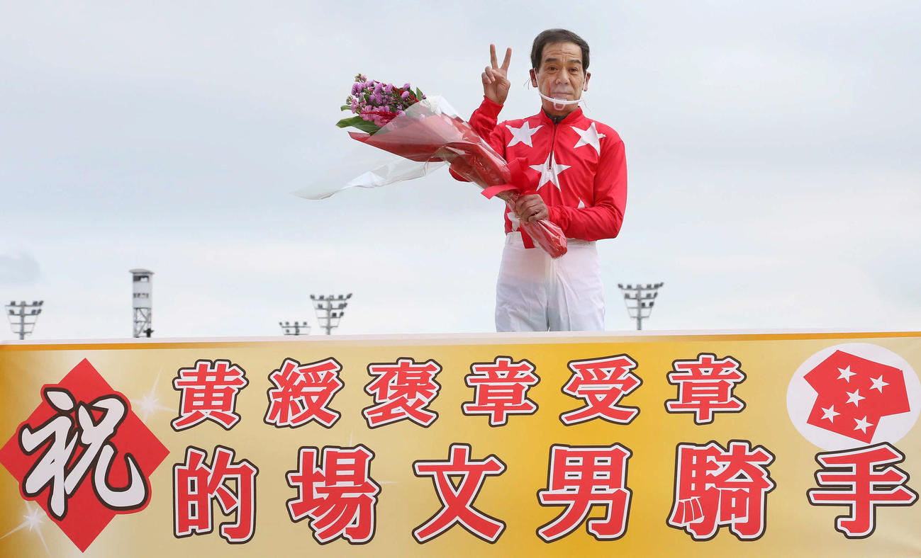 花束を手にポーズをとる黄綬褒章を受賞した的場騎手（2020年11月3日撮影）