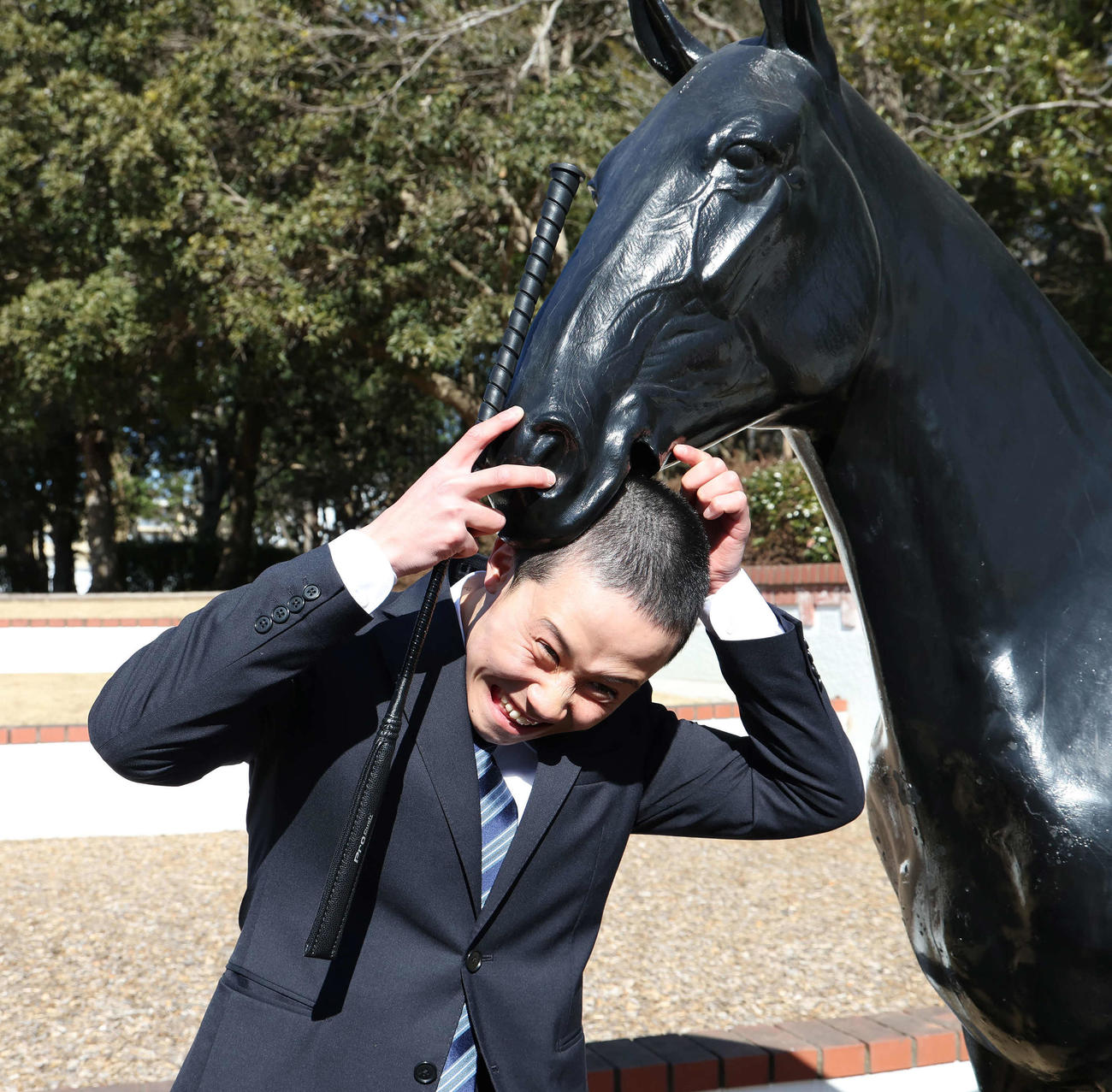 ムチ贈呈式を終えて馬に頭をかまれる遠藤汰月（撮影・丹羽敏通）
