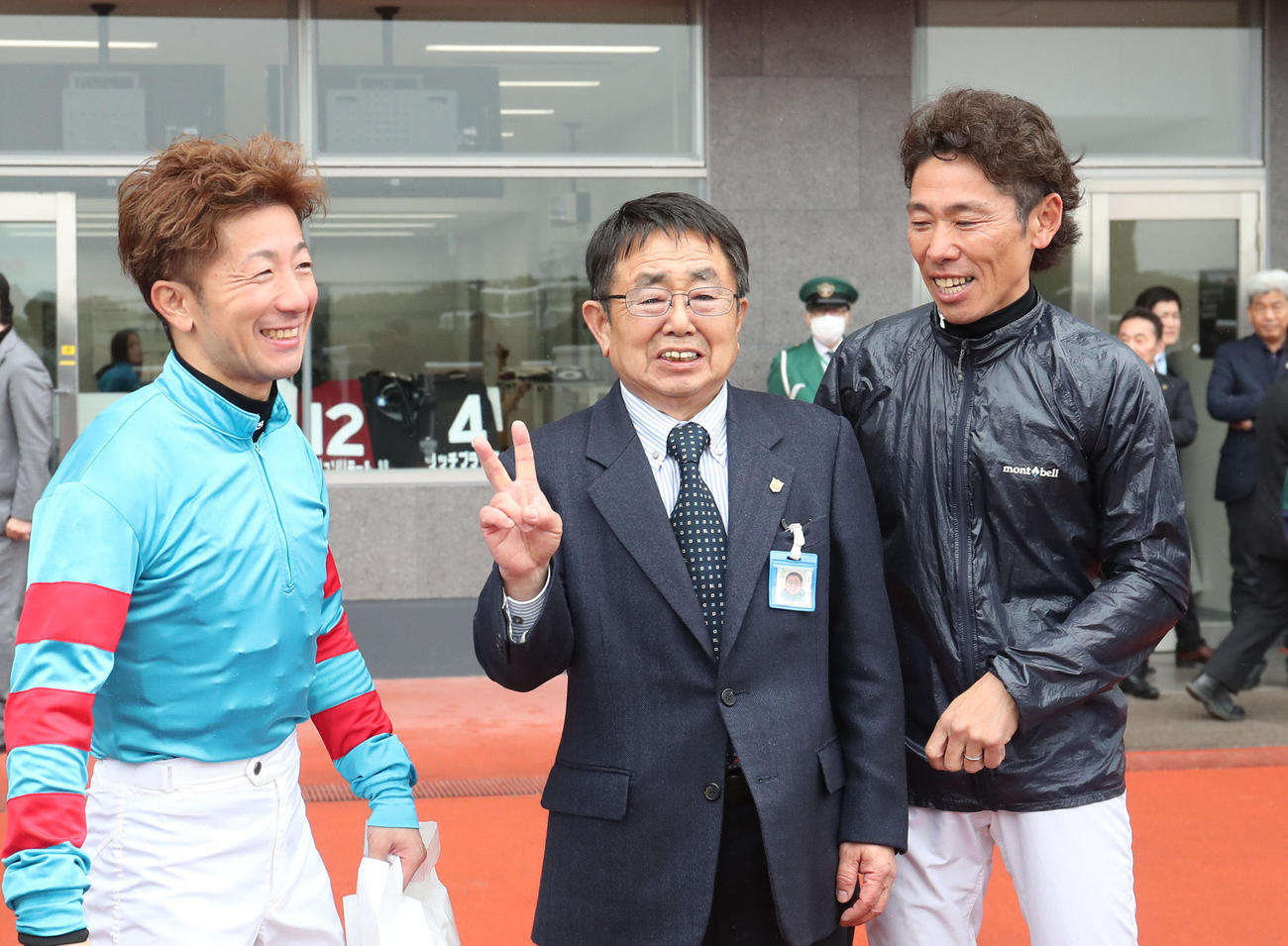 阪神4R、酒井騎手（左）と古川吉騎手（右）に囲まれてピースする木原師（撮影・白石智彦）