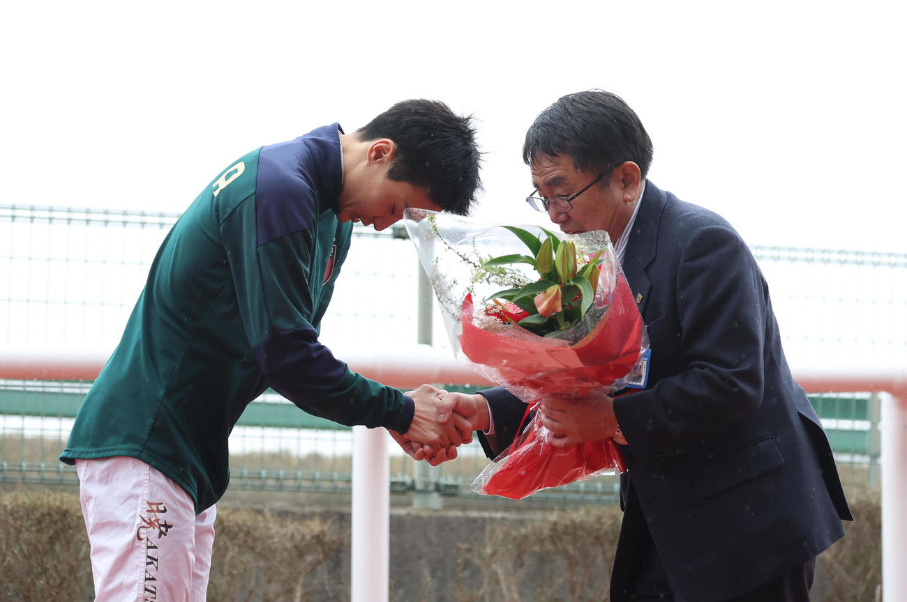 阪神4R、師匠の木原師（右）に握手する弟子の富田騎手（撮影・白石智彦）