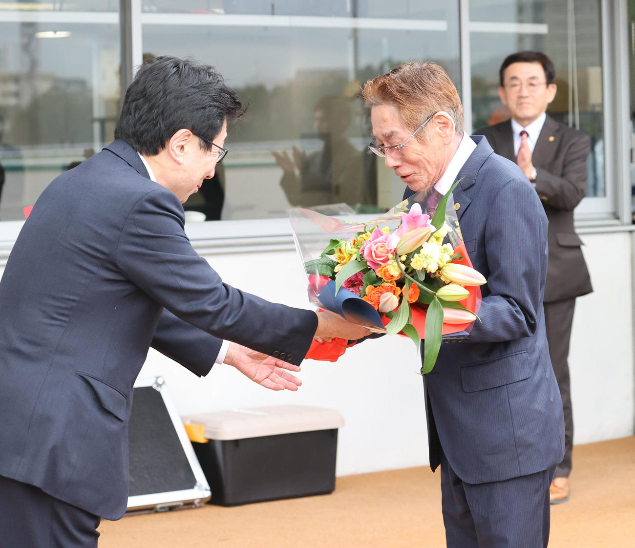 第1回小倉競馬第12日　定年引退する河内調教師は関係者に花束を贈られ笑顔を見せる（撮影・梅根麻紀）
