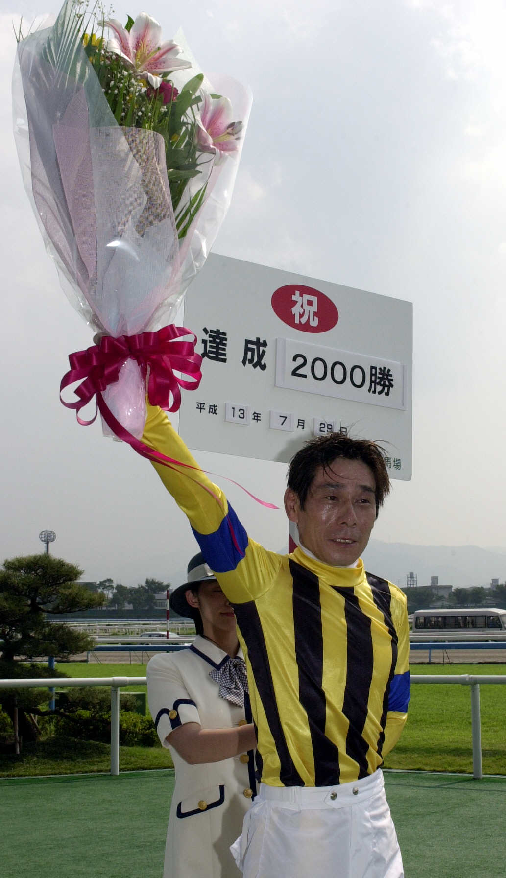 01年7月、通算2000勝を達成した河内騎手は、JRAから贈られた花束を高々とあげる