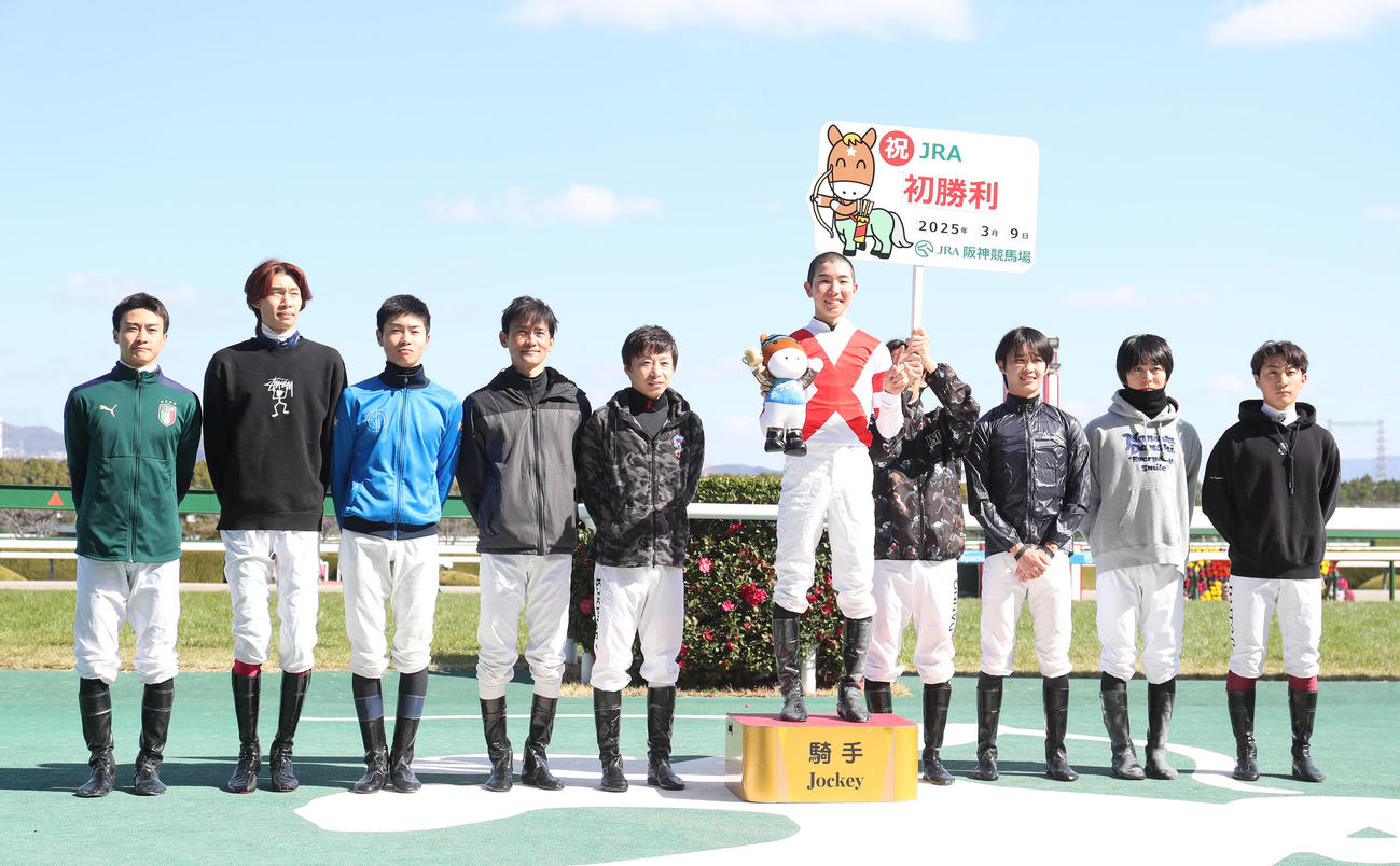 先輩騎手たちに祝福され記念写真に納まるJRA初勝利を挙げた田山騎手（中央）（撮影・白石智彦）