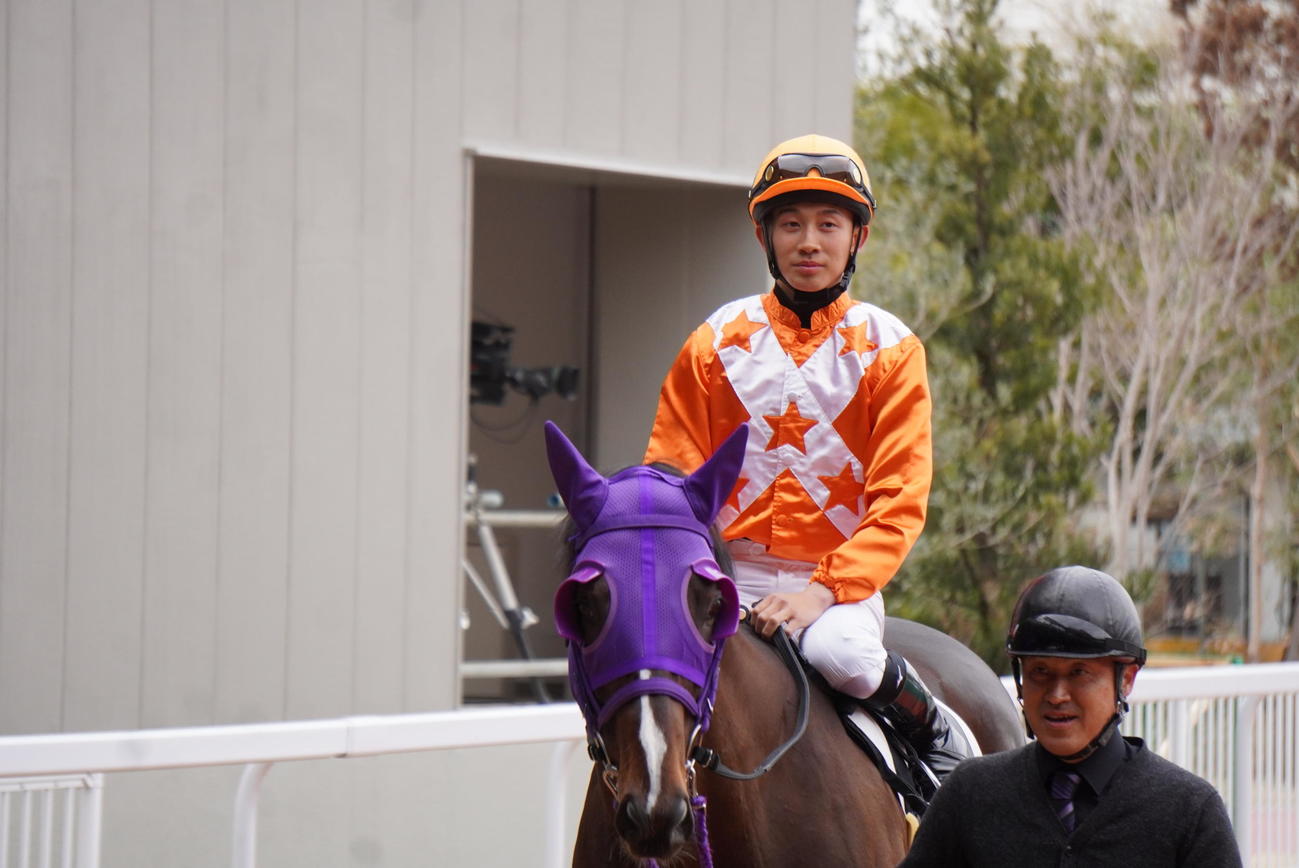 パドックから馬場に向かう舟山瑠泉騎手と父の浩厩務員