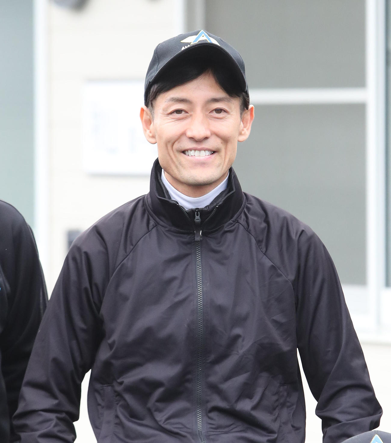 笑顔で記念写真に納まる秋山師（撮影・白石智彦）