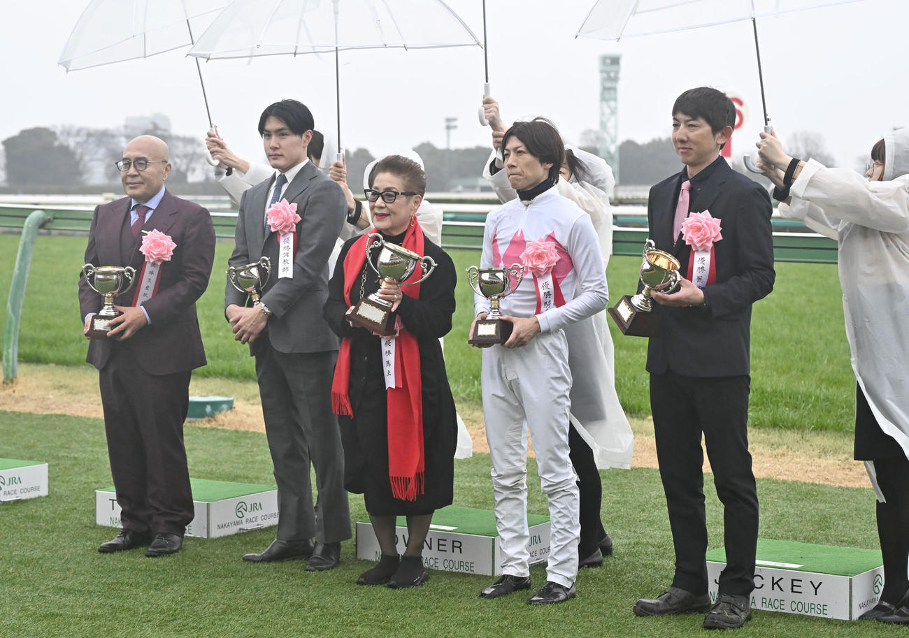 スプリングS制し、優勝カップを手に記念撮影する上原佑師（左から2人目）、石橋騎手（同4人目）と関係者