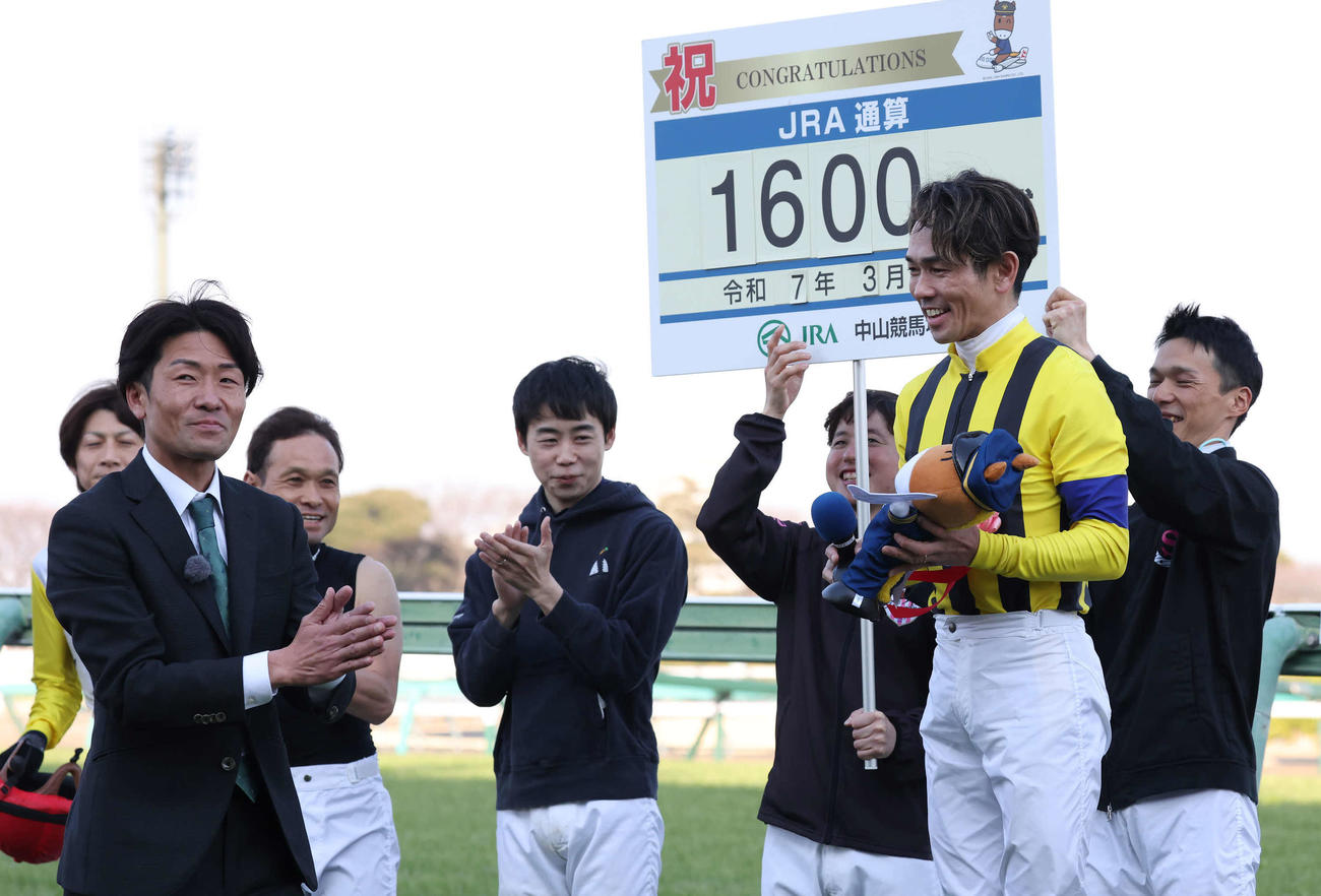 JRA通算1600勝を達成して引退した元騎手の森氏（左）の祝福を受ける戸崎騎手（撮影・丹羽敏通）