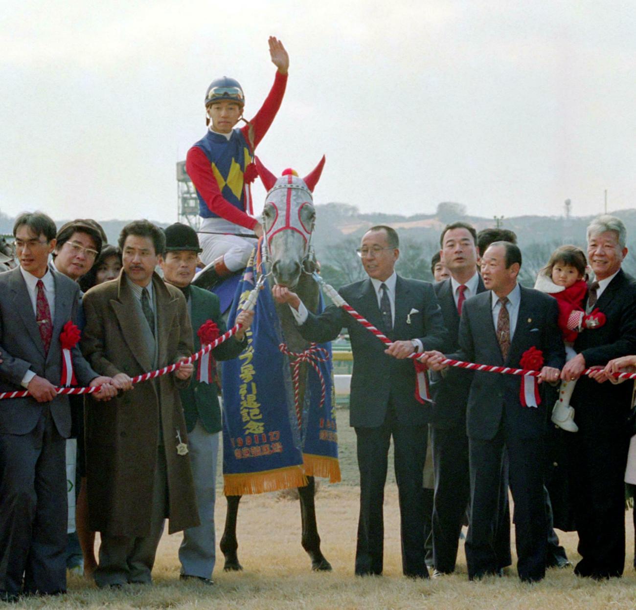 武豊騎手を背に引退式で関係者と記念撮影するオグリキャップ（1991年1月27日撮影）