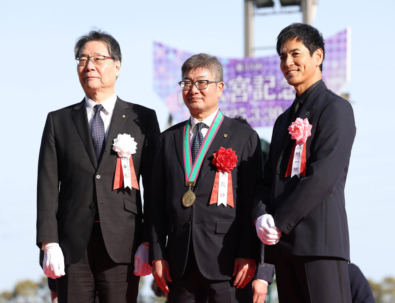 記念写真に納まる左から、吉田正義JRA理事長、堀師、プレゼンターの沢村一樹（撮影・白石智彦）