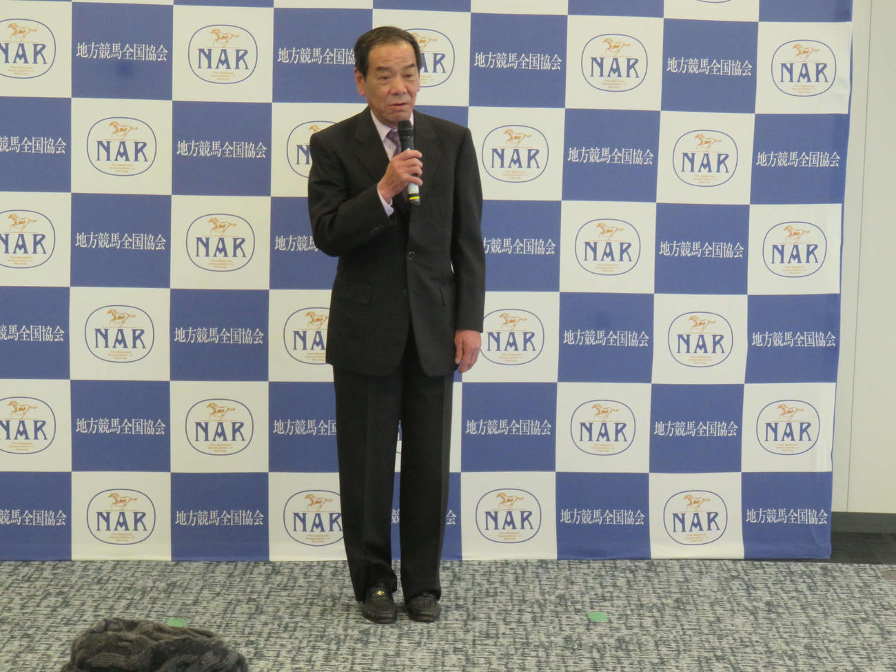 免許返納式であいさつする的場文男騎手の珍しいスーツ姿