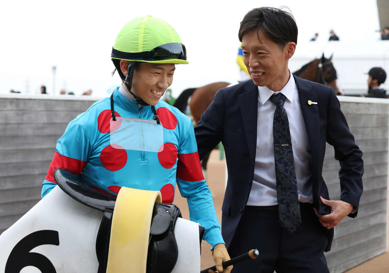中山8R、ビジューブリランテで4歳上1勝クラスを制して厩舎に初勝利をもたらした荻野極騎手（左）を迎える浅利師（撮影・丹羽敏通）