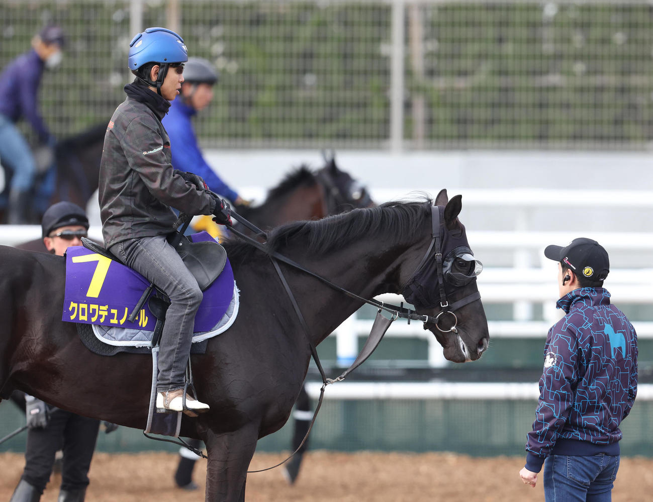 北村友騎手を背に角馬場で調整するクロワデュノール。右は様子を見る斎藤崇師（撮影・白石智彦）