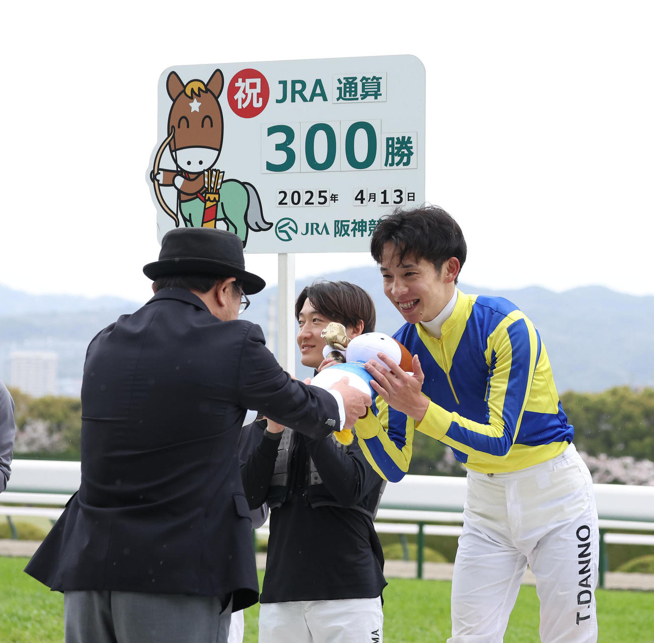 阪神3R、JRA通算300勝を達成し佐々木晶三調教師（左）から記念のターフィー人形を贈呈される団野大成騎手