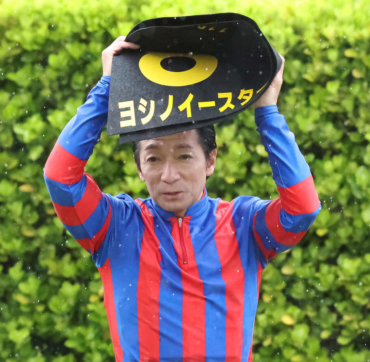 ヨシノイースターで春雷Sを制して、ゼッケンで雨をしのいで口取りに向かう内田騎手（撮影・丹羽敏通）