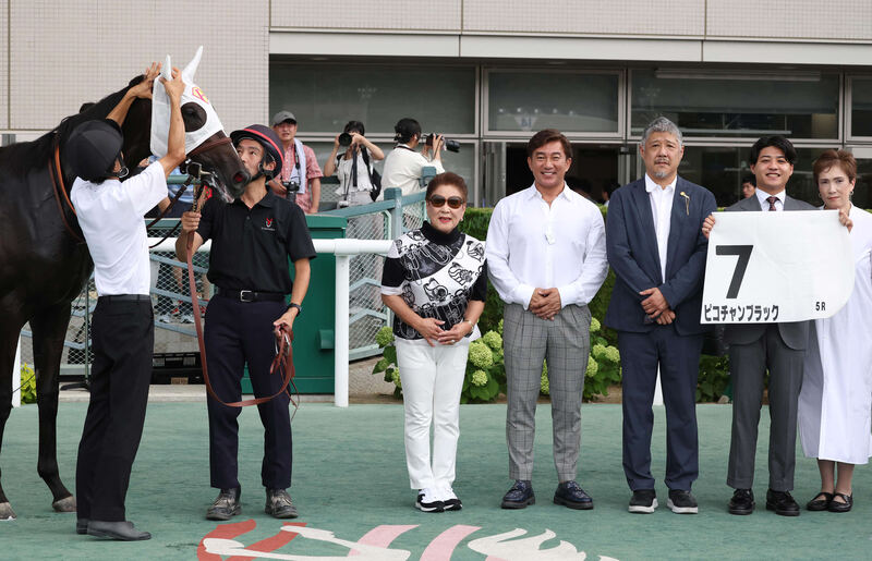 24年７月福島新馬戦を勝ったピコチャンブラックと記念写真に納まる石部美恵子オーナー（左から3人目）