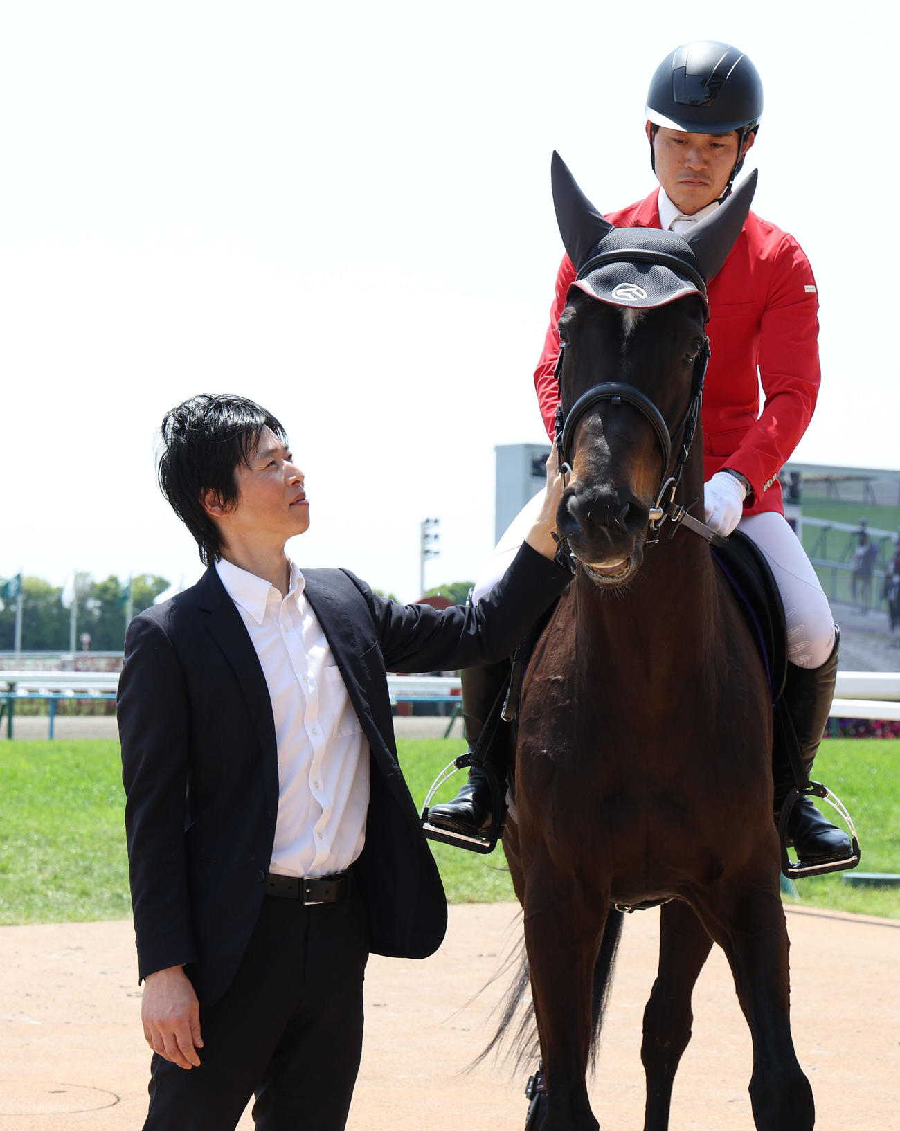 誘導馬デビューしたディープボンドと再会した谷口助手（撮影・白石智彦）
