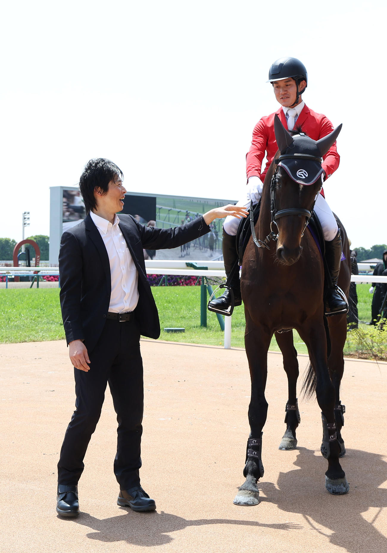 誘導馬デビューしたディープボンドと再会した谷口助手（撮影・白石智彦）