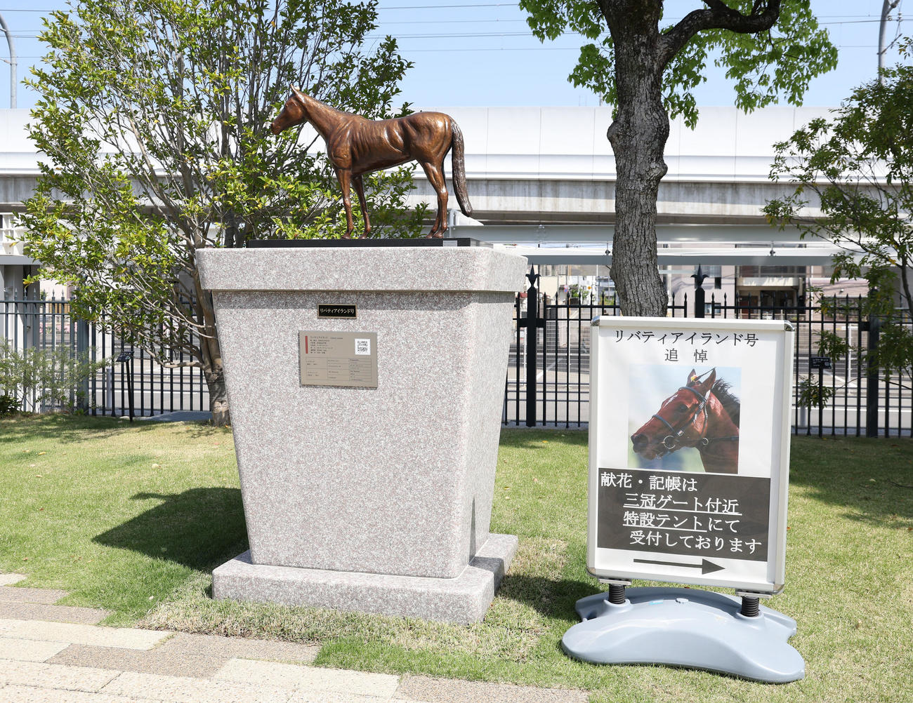 リバティアイランドの銅像と献花と記帳お知らせの看板（撮影・白石智彦）