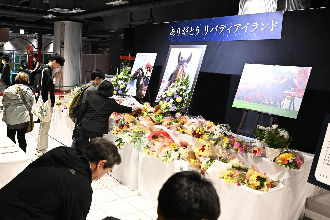 リバティアイランドを追悼して設けられた献花台で記帳する人たち（撮影・千葉一成）