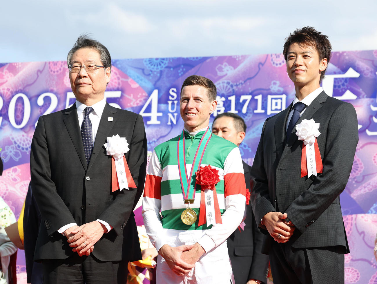 記念写真に納まる左から、吉田正義JRA理事長、レーン騎手、プレゼンターの竹内涼真（撮影・白石智彦）