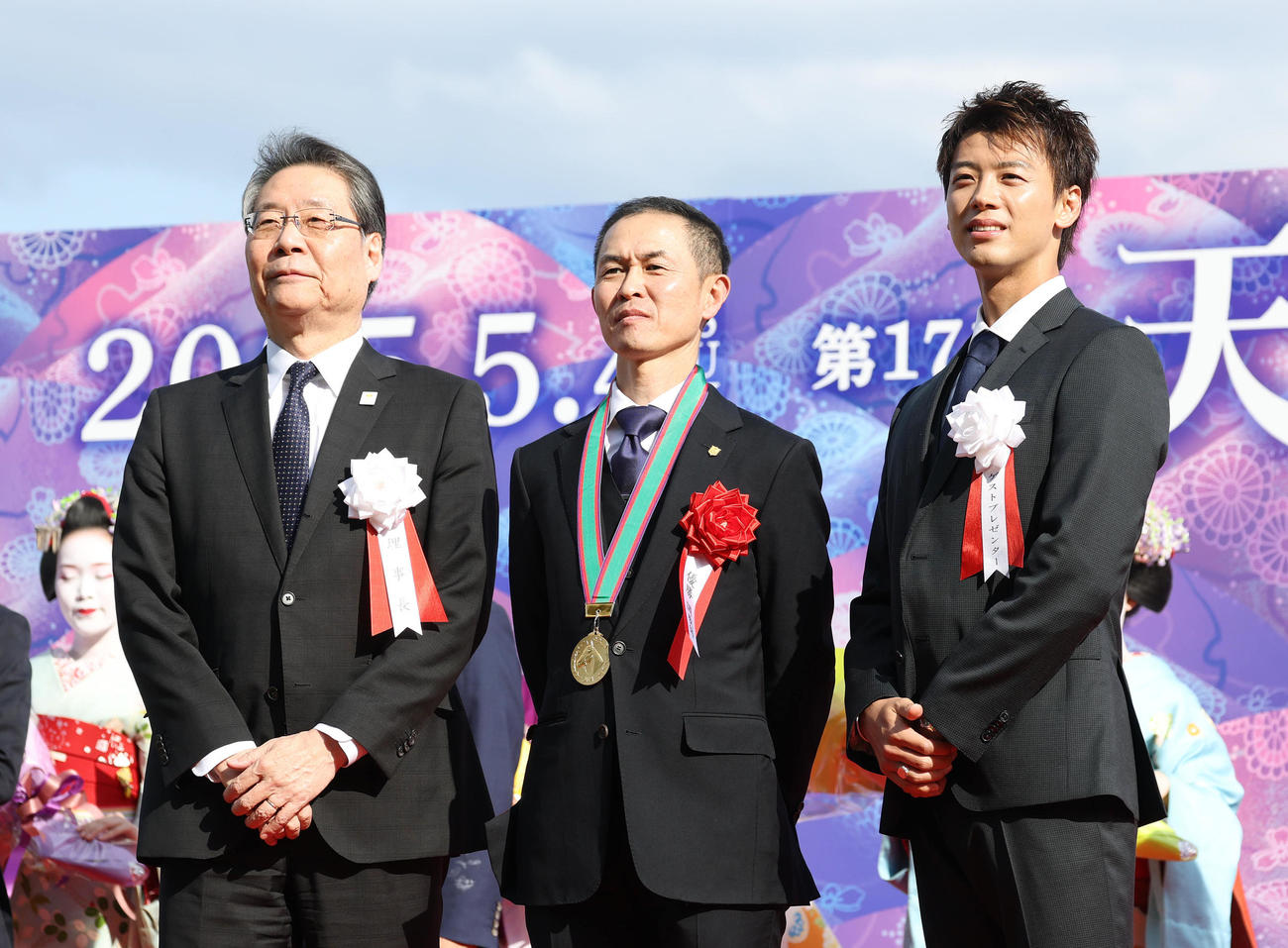 記念写真に納まる左から、吉田正義JRA理事長、木村師、プレゼンターの竹内涼真（撮影・白石智彦）