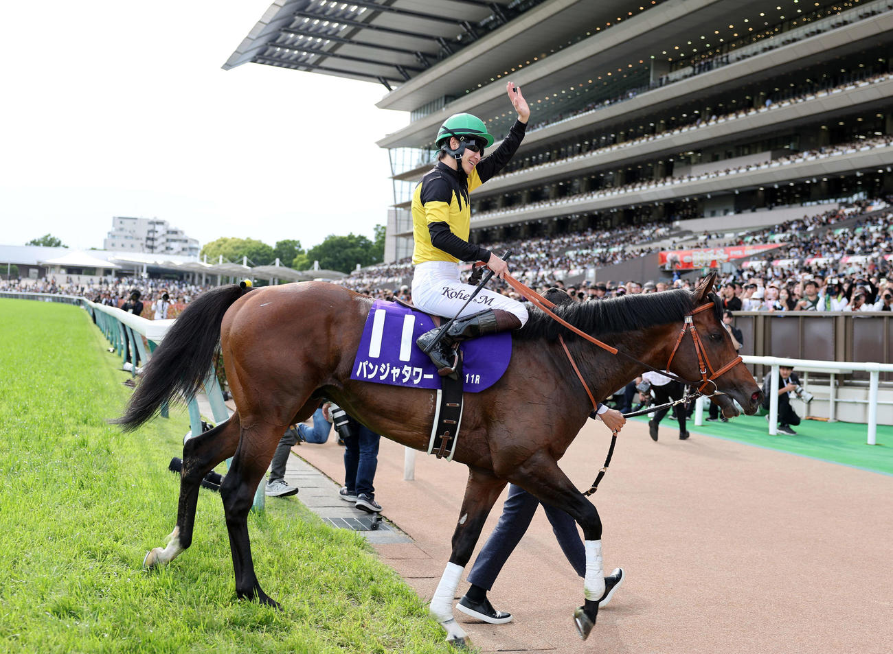 パンジャタワーでNHKマイルCを制した松山騎手はファンに手を振り引き揚げる（撮影・鈴木正人）
