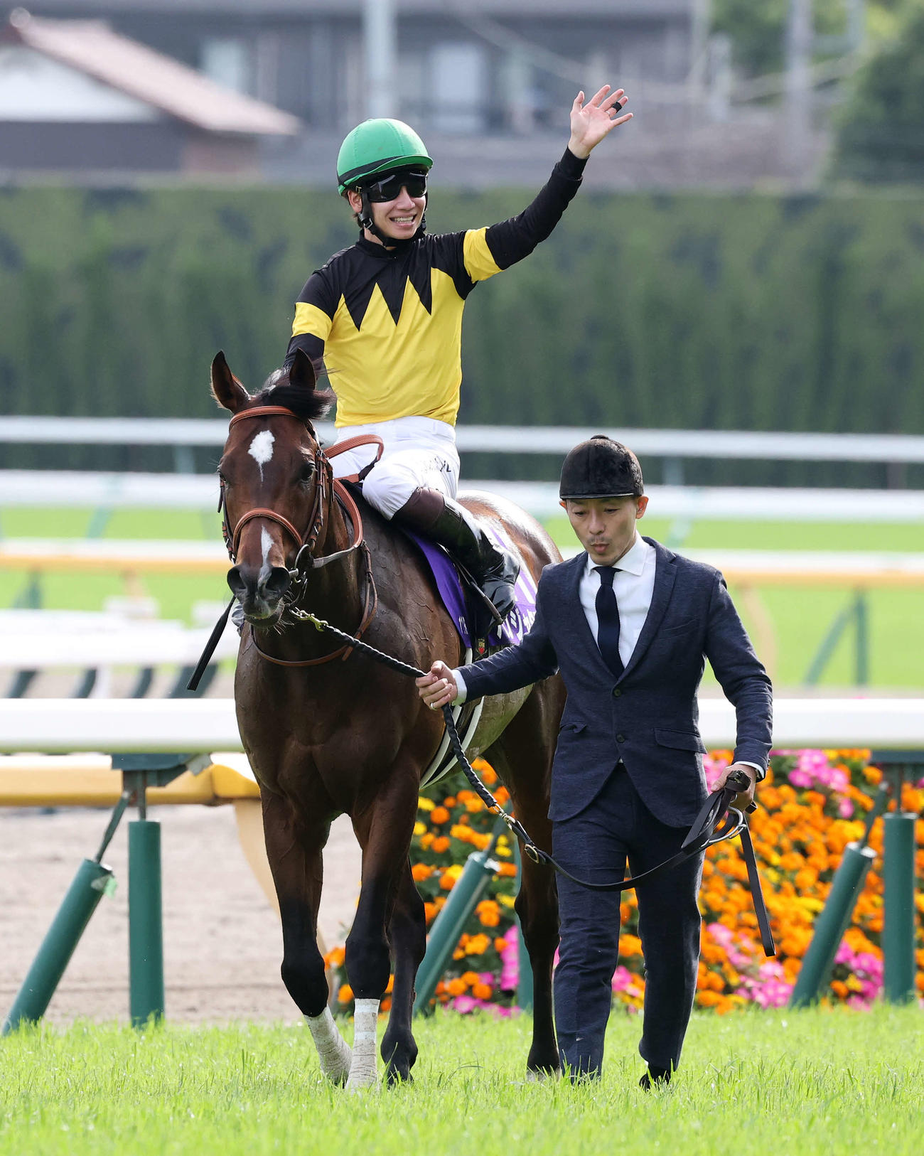 NHKマイルCを制したパンジャタワーと、ファンに手を振り引き揚げる松山騎手（撮影・鈴木正人）