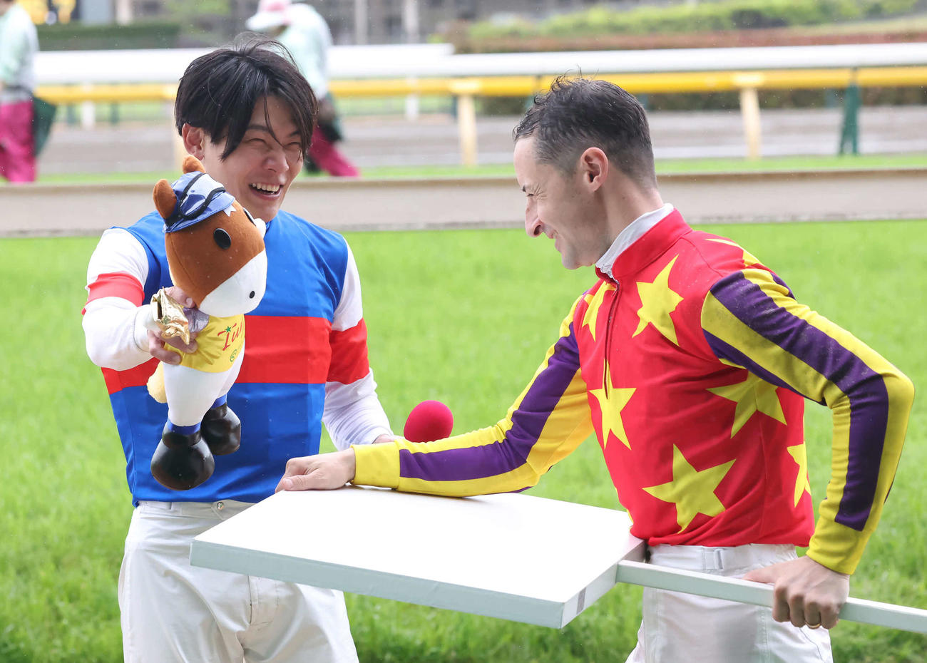 JRA通算1100勝を達成した三浦騎手（左）はルメール騎手の祝福に笑顔を見せる（撮影・丹羽敏通）