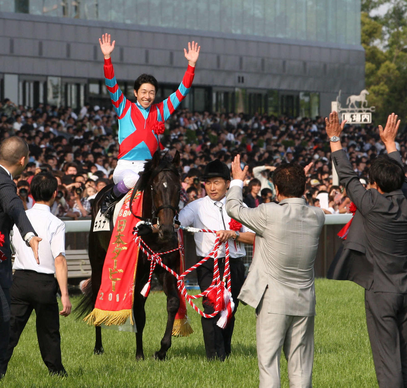 13年5月、ダービーを制して、口取りに向かう武豊騎手はキズナの鞍上で万歳する