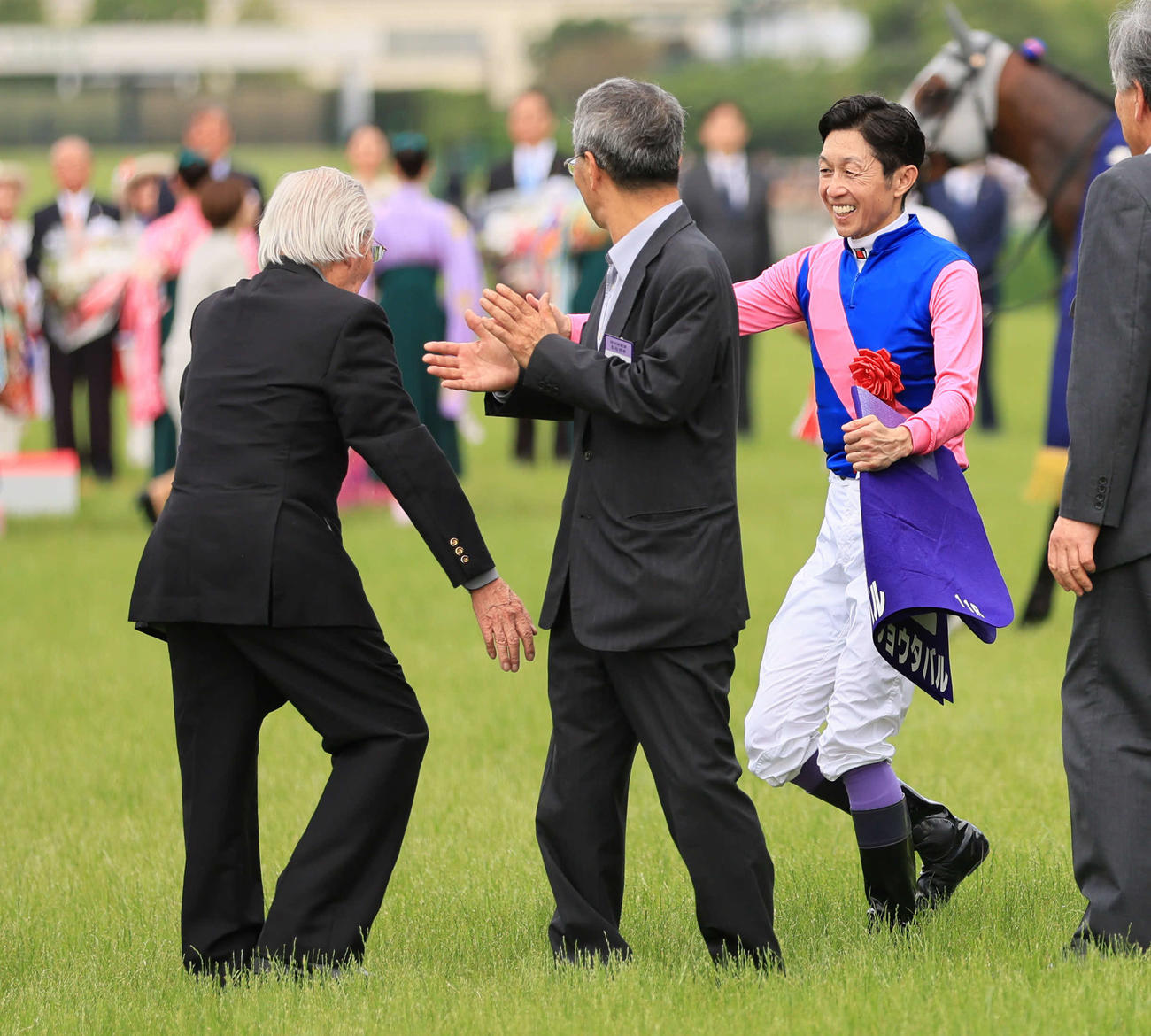 阪神11R、宝塚記念を制した武豊騎手を迎える松本オーナー（左）（撮影・宮崎幸一）