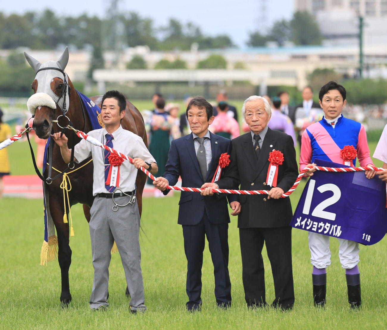 宝塚記念を制し口取りに臨む（左から2人目から）石橋師、松本オーナー、武豊騎手