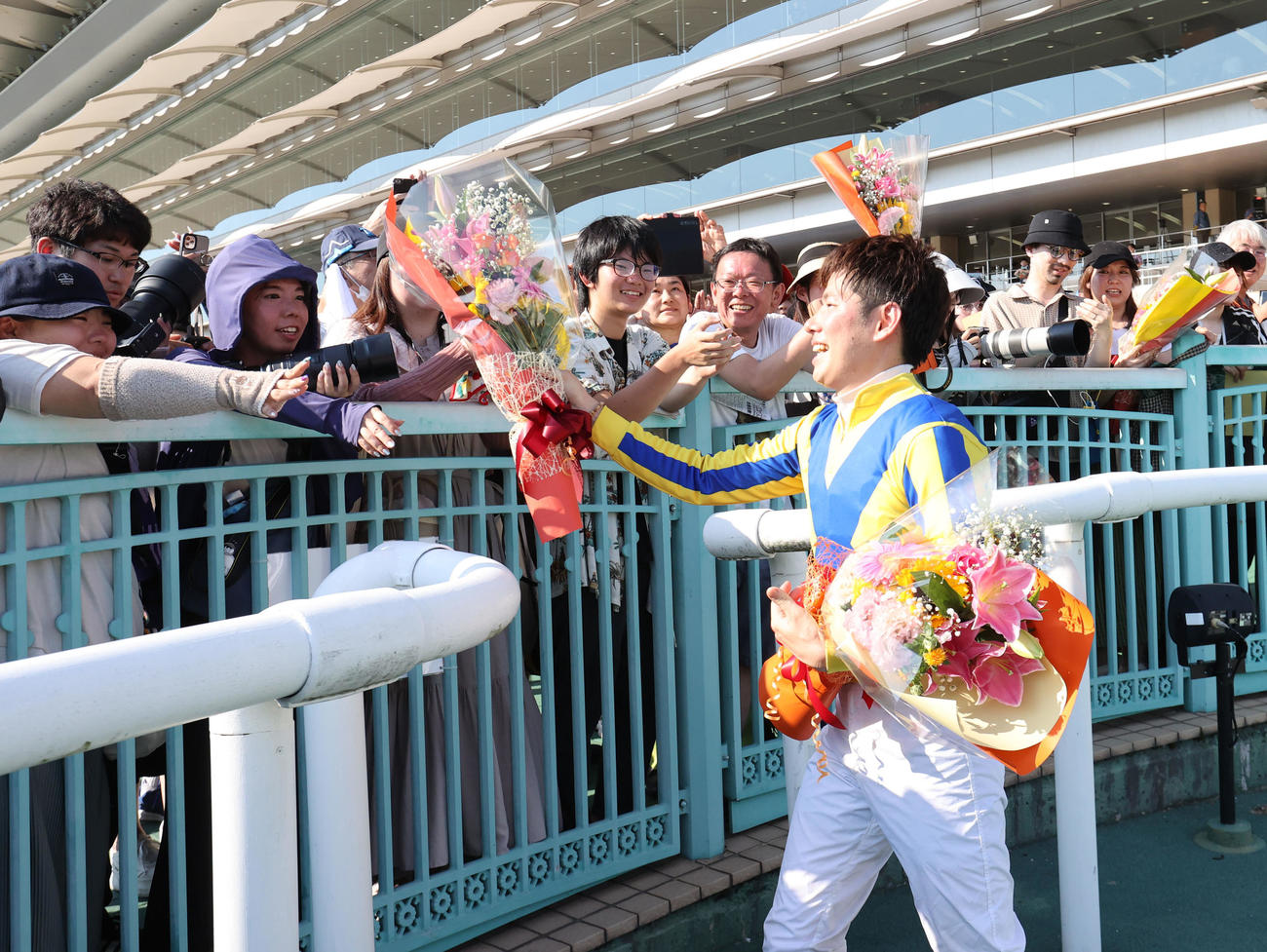 小倉競馬場での騎乗を終えた水口騎手はファンに花束を渡す（撮影・梅根麻紀）
